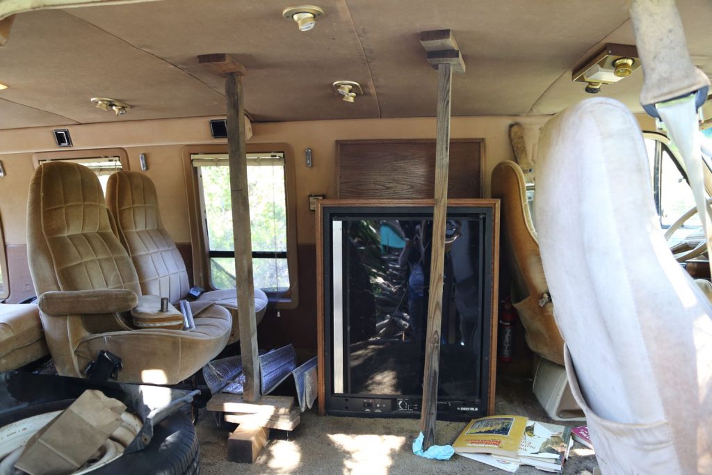 At some point in its 10 year hermitage in the woods, Dodgy had an encounter with some unscrupulous characters who did not consider the effects of jumping on the roof.  The resulting structural cave in left Dodgy with a look that we like to call "Grecian," what with the structural support pillars.  You can also see the original refrigerator and seats.