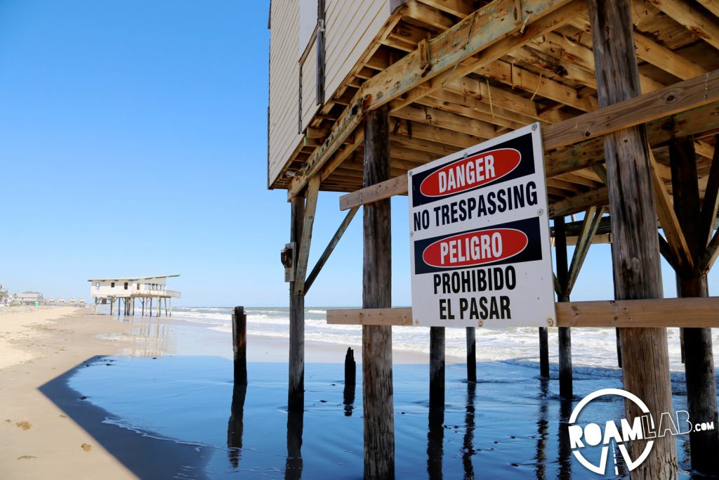 Condemned stilt houses lined the beach along the tide line.