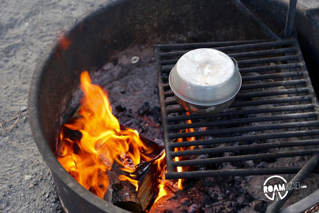 Covered tin pot of water over the fire for cooking a freeze dried dinner.