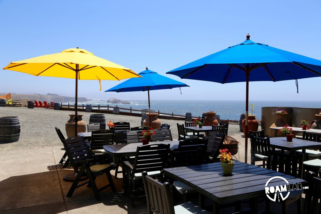 Picnic tables set up along the sea side at Pacific Star Winery.