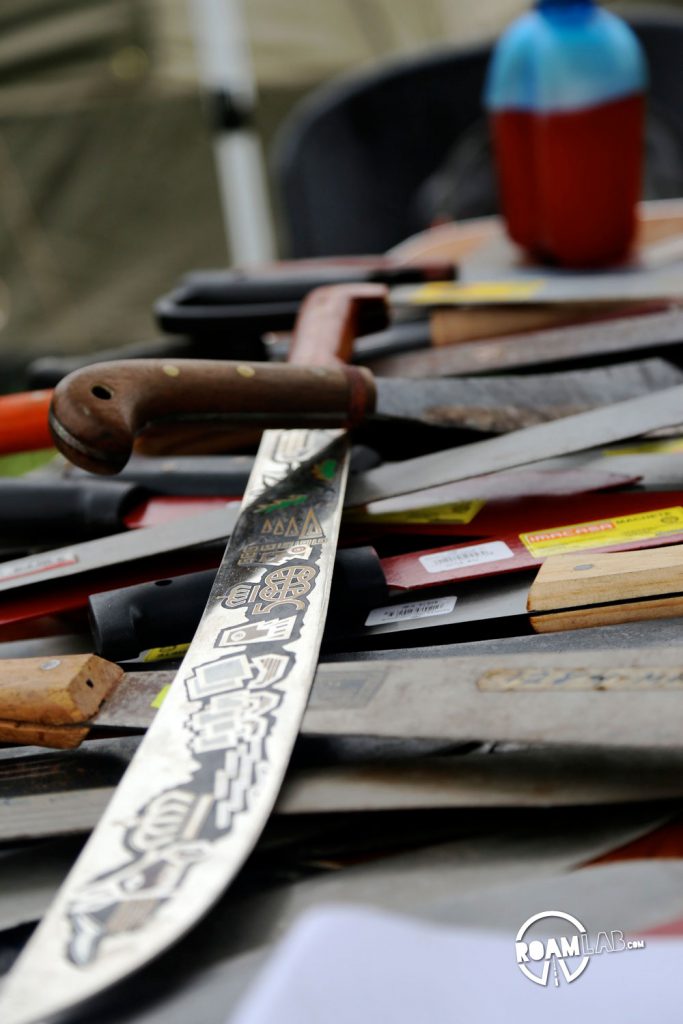 Overland Expo East 2016 includes lectures, workshops, and show "rooms" for adventurers looking to push the limits and discover new people, places, and experiences. As part of one workshop, a pile of machetes line the table: demonstrating their many shapes, sizes, and uses.