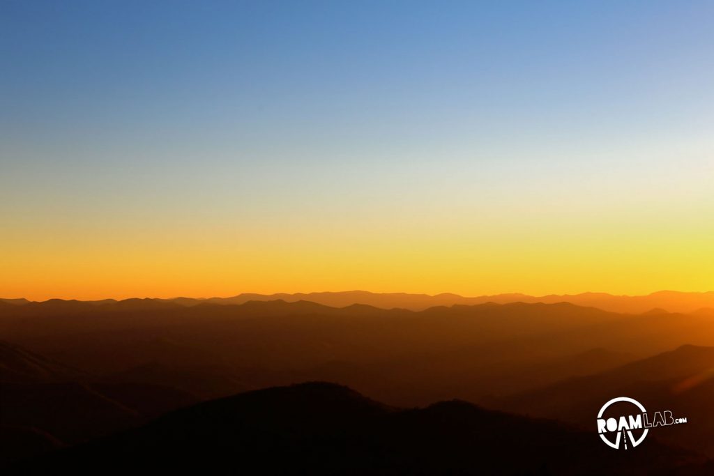 The Great Smoky Mountains National Park bathed in gold just as the sun is about to set from the Blue Ridge Parkway.
