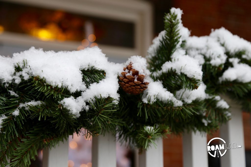 Fresh snow dusting the pine decorations along the inn.