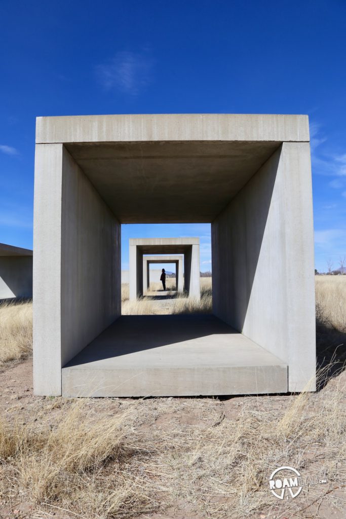 Exploring a collection of concrete sculptures by Donald Judd outside the Chinati Foundation.
