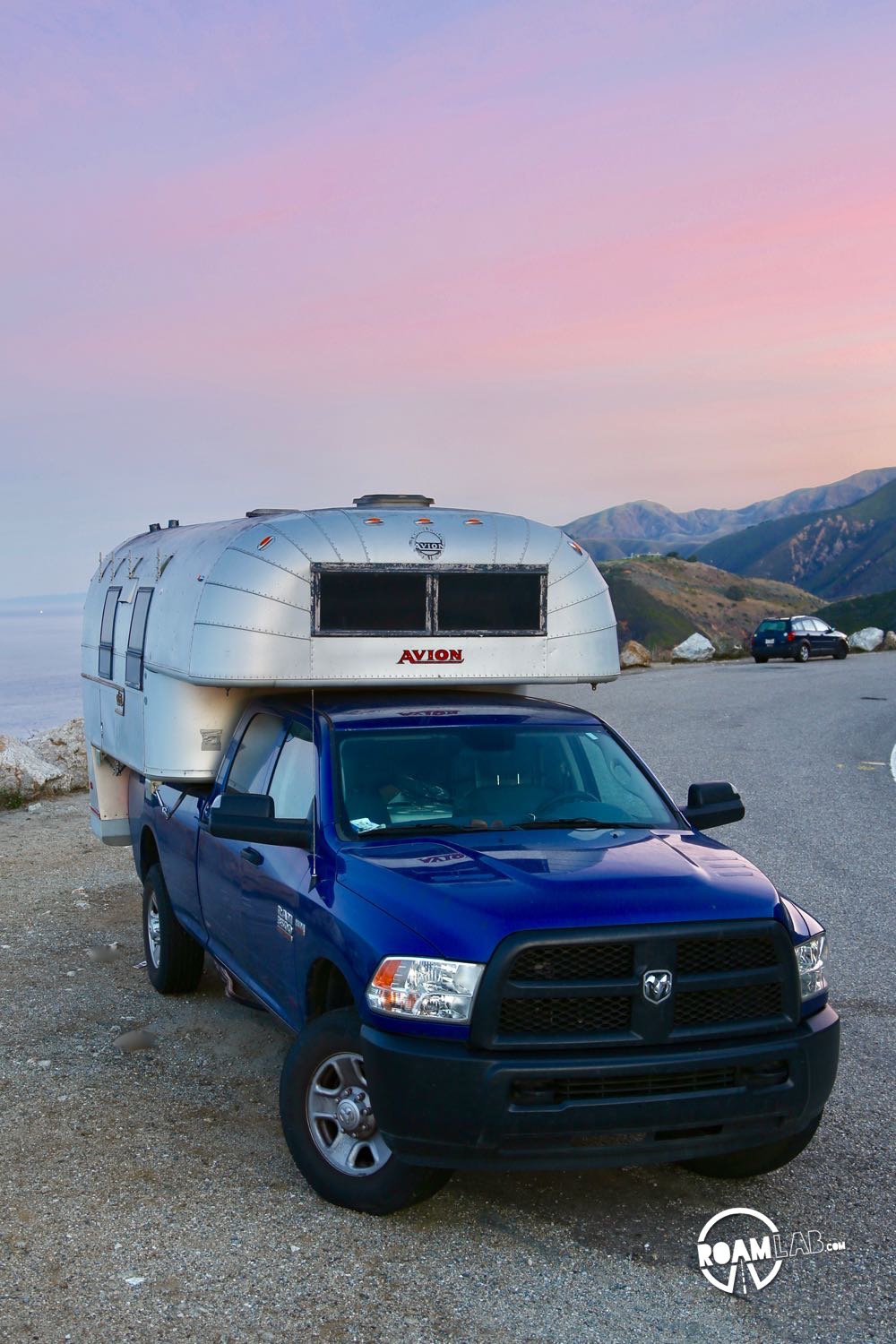 1970 Avion C11 truck camper parked by the ocean at sunrise.