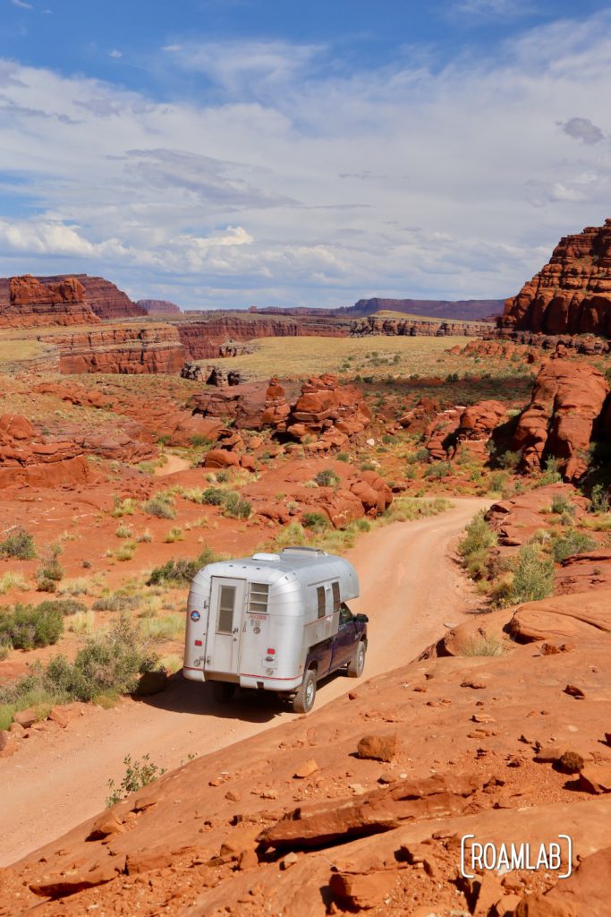 Aluminum Avion C11 truck camper driving down Shafer Road through Canyonlands National Park.