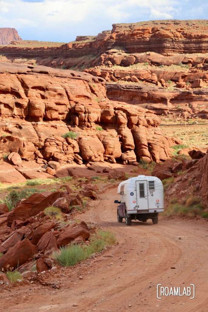 Aluminum Avion C11 truck camper driving down Shafer Road through Canyonlands National Park.