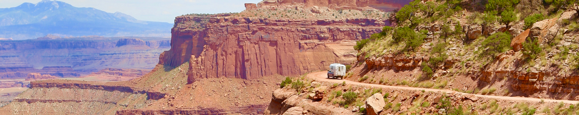 1970 Avion C11 truck camper traveling down Shafer Trail in Canyonlands National Park.