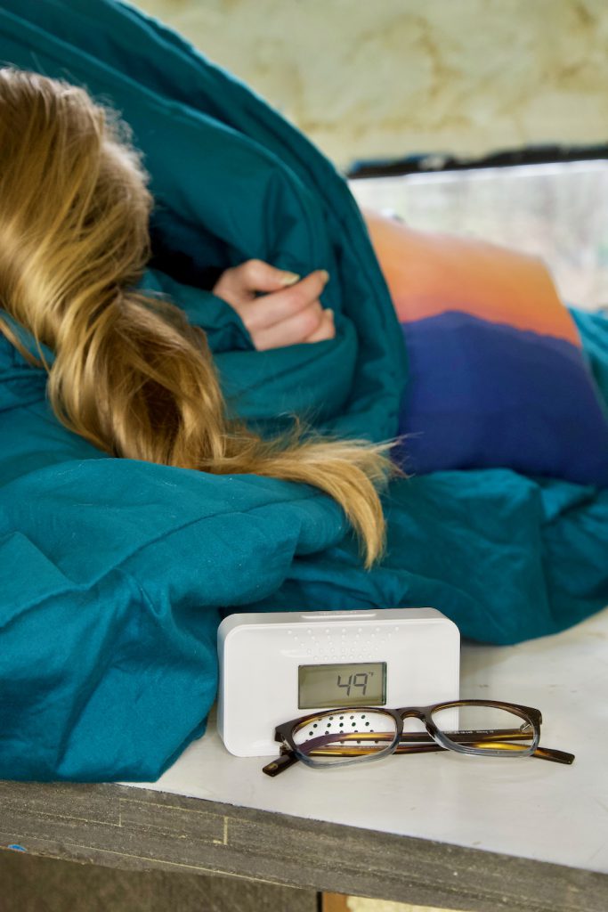 Woman sleeping next to carbon monoxide alarm.