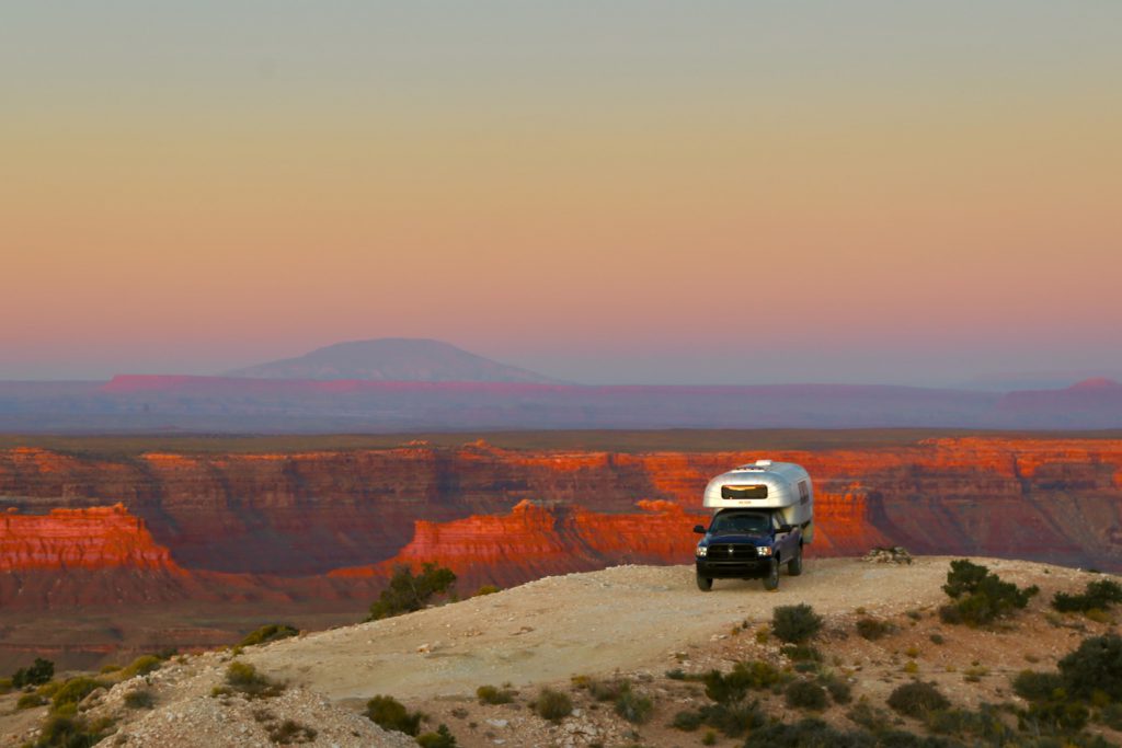 Vintage truck camper at sunrise in the Utah wilderness.