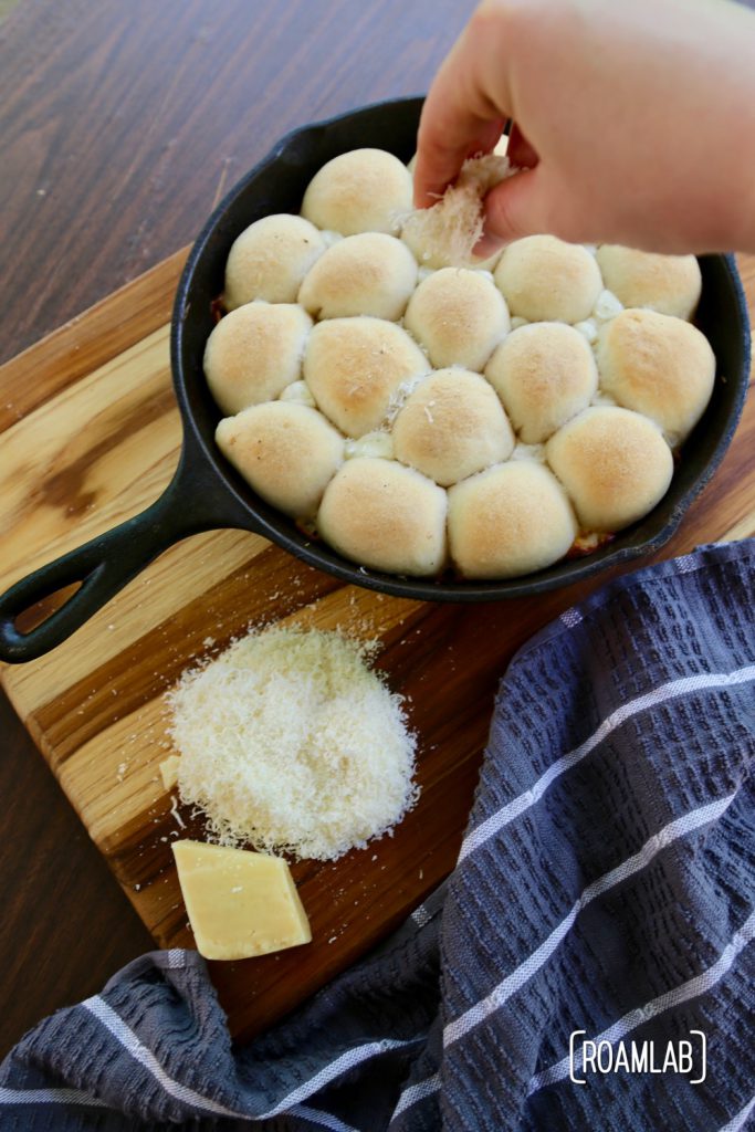 Preparing cast iron skillet cheesy buns.