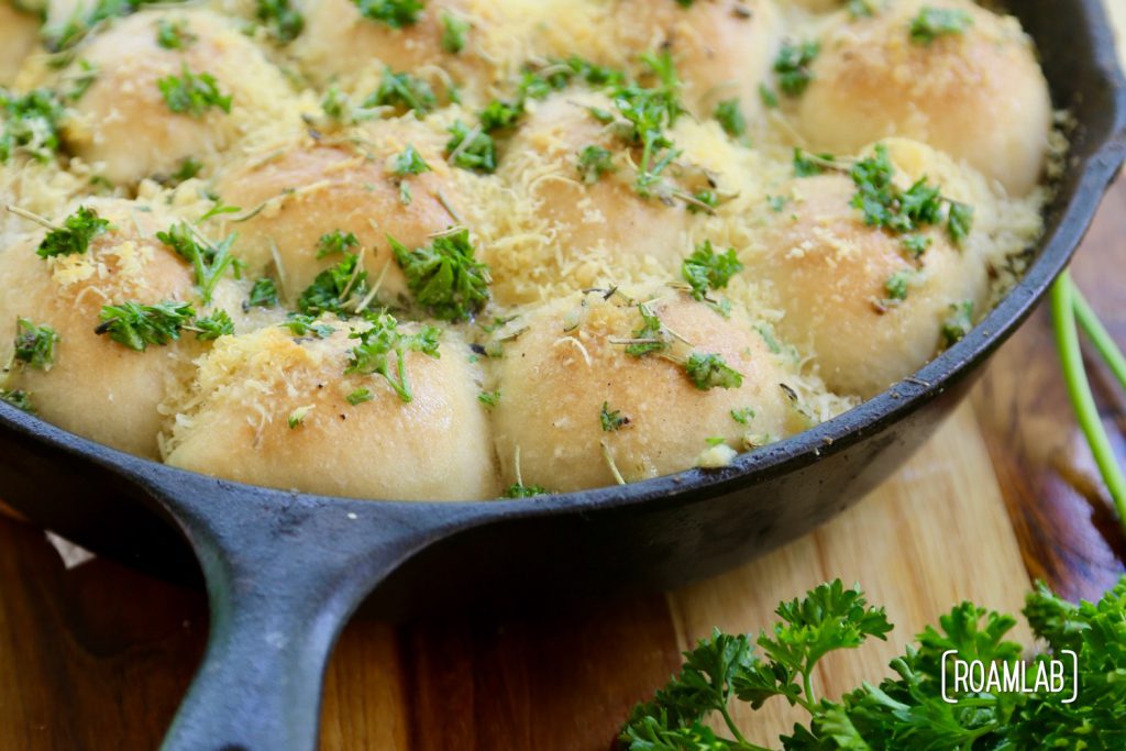 Cast iron skillet cheesy buns and parsley.