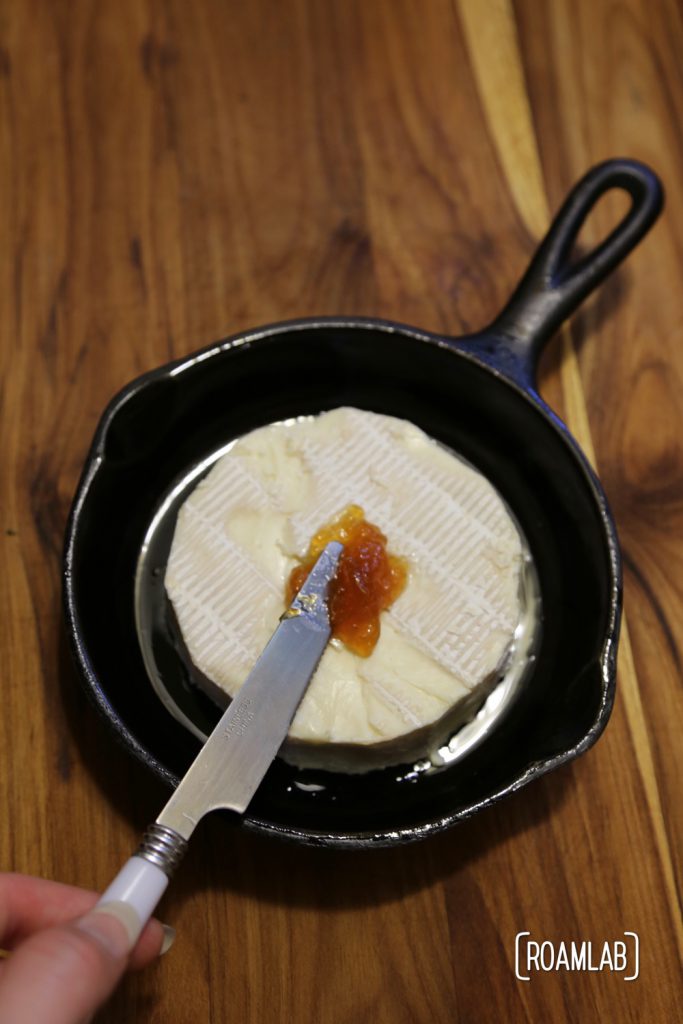 Preparing a campfire almond apricot baked brie