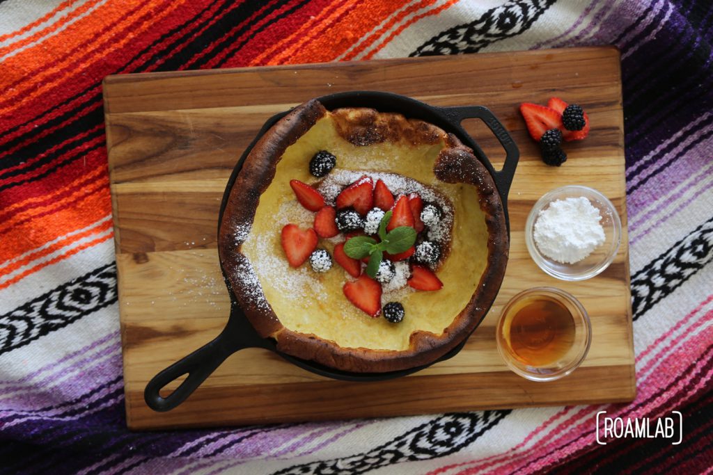 Blackberries, strawberries, powdered sugar and mint on a dutch baby pancake.