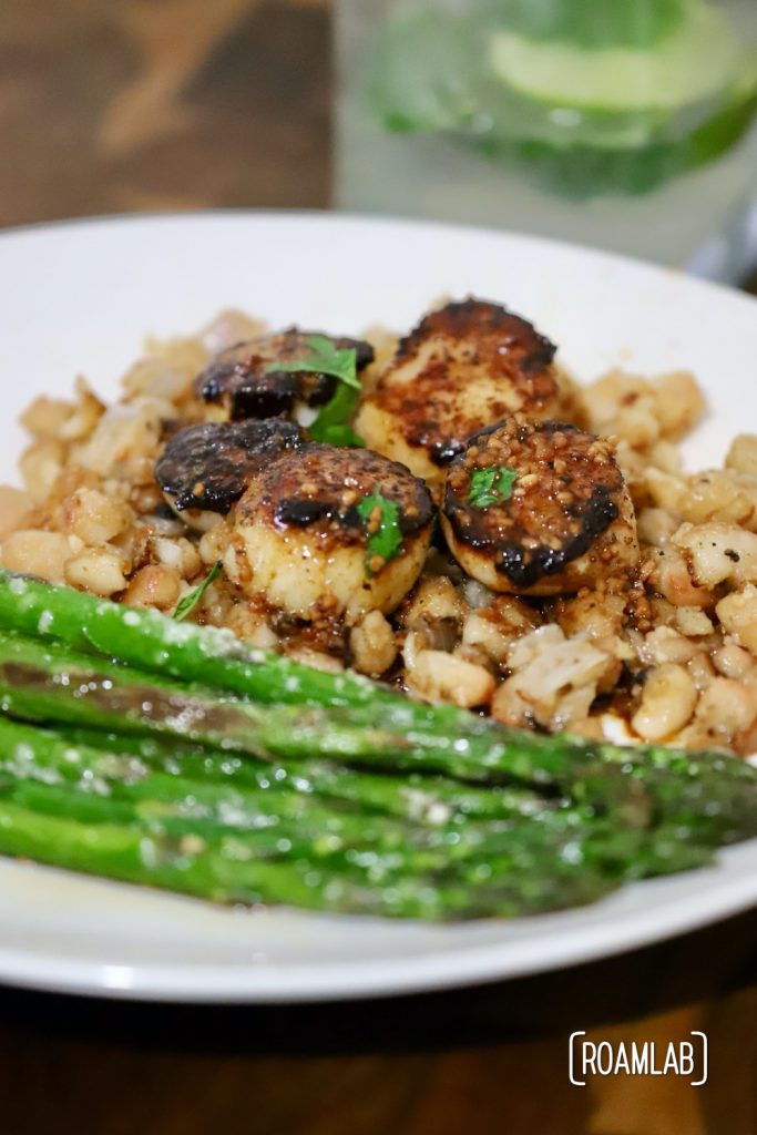 Enjoy this seafood delight of seared sea scallops on a bed of parmesan white beans for a campfire cooking dinner recipe treat from the Roam Lab team.