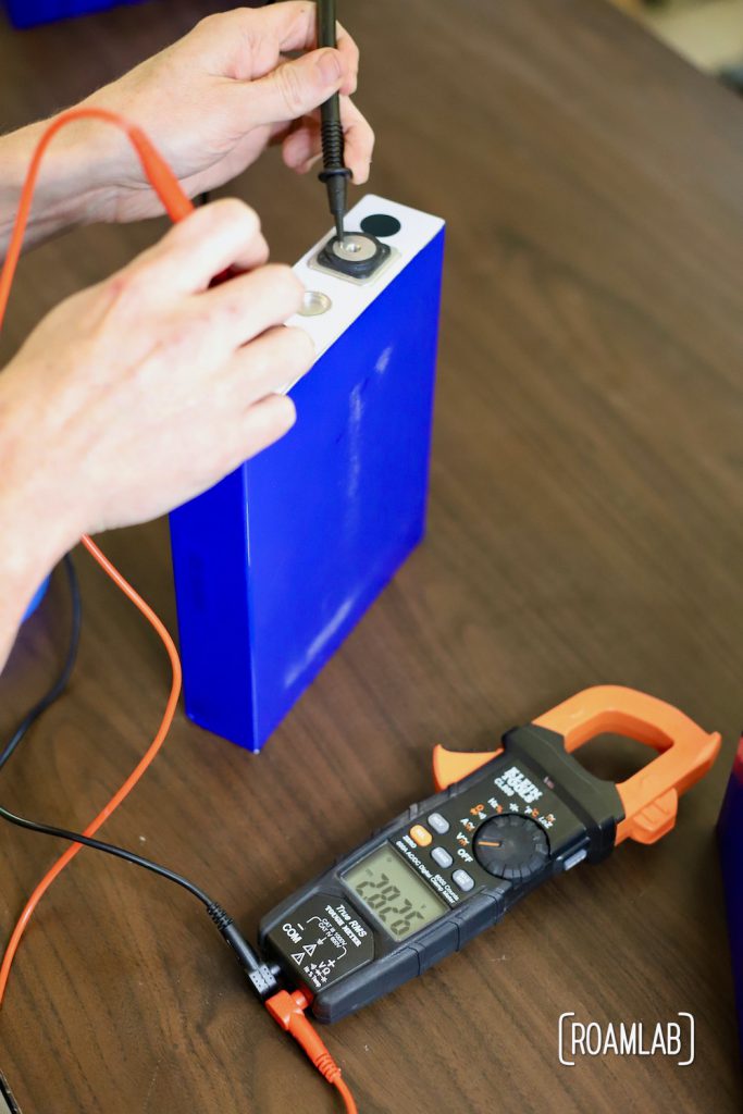 Checking the voltage of a battery cell.