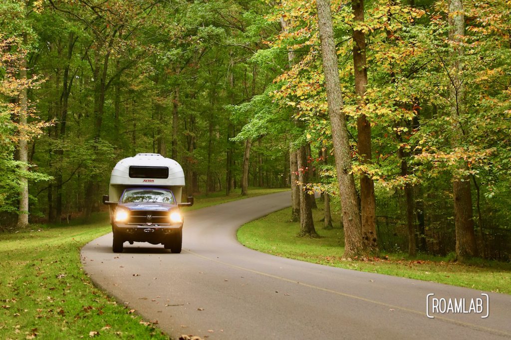 1970 Avion C11 truck camper driving the scenic roads of Montgomery Bell Tennessee State Park in Fall.
