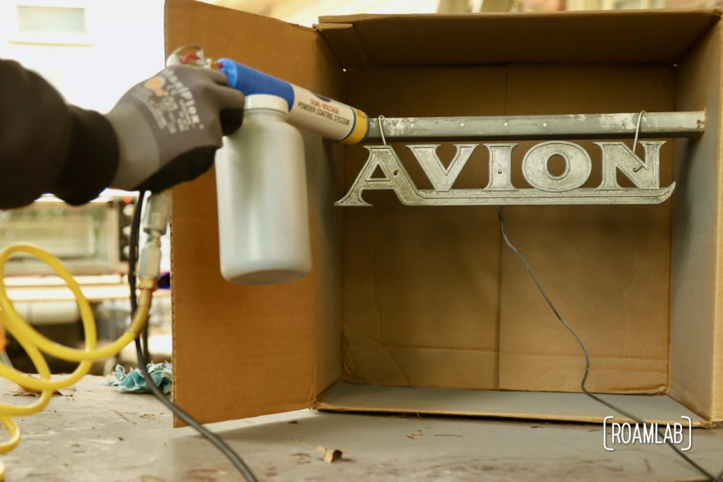 Avion emblem hooked up to the powder coating gun assembly, ready for application.