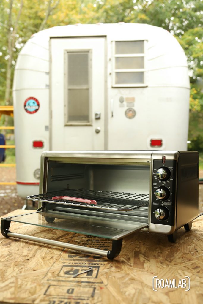 Emblem cooling after curing in the toaster oven with an Avion truck camper in the background.