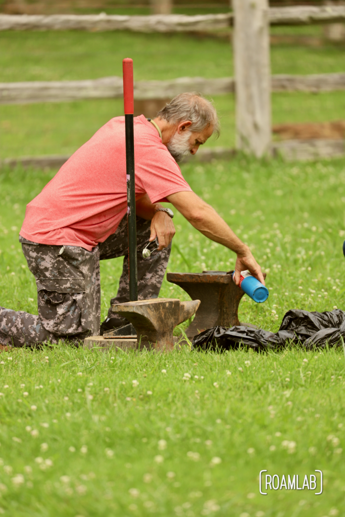 Man pouring black powder on an anvil in preparation of an anvil shoot.