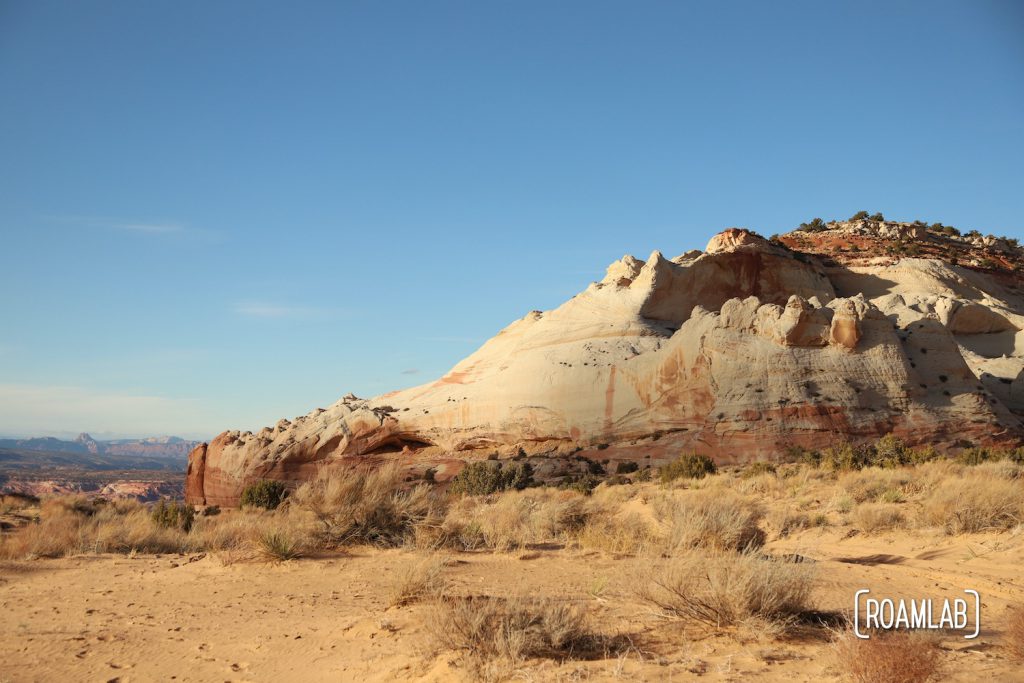 Pinkish white rock formation surrounded by sand in White Pocket.