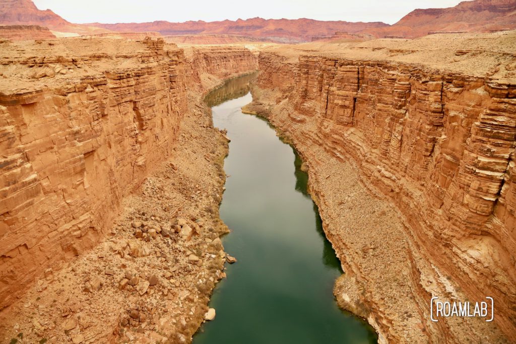 The wide Colorado River flowing between the golden cliffs of the Marble Canyon.