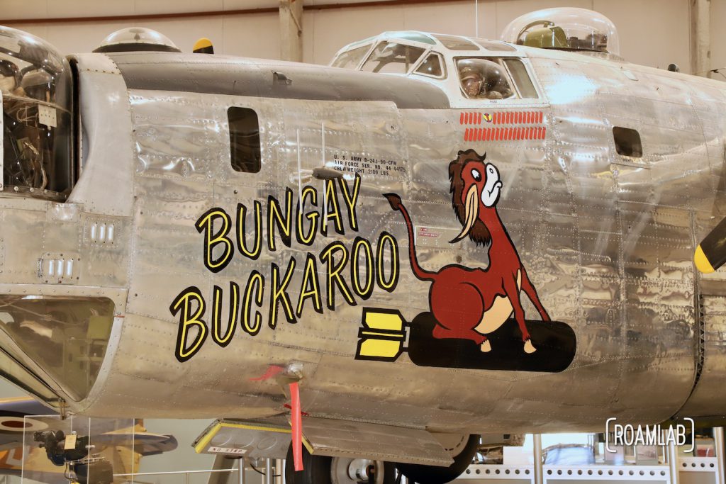 Nose art on the side of an aluminum fighter plane featuring a donkey on a bomb with text "Bungay Buckaroo" in the Pima Air & Space Museum