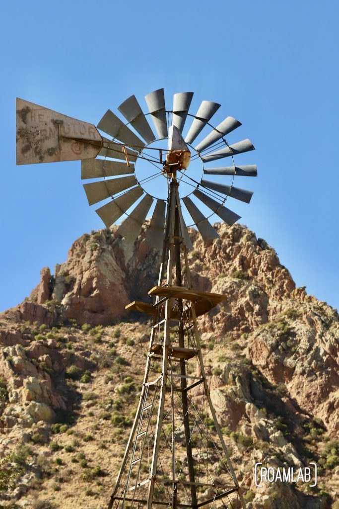 Faraway Ranch windmill with rocky hilltop in the background along the Silver Spur Meadow Trail in Chiricahua National Monument Arizona.