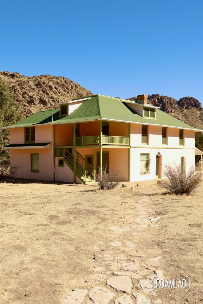 Pink and green two story home known as Faraway Ranch House with a rocky ridge in the background along Silver Spur Meadow Trail in Chiricahua National Monument Arizona.