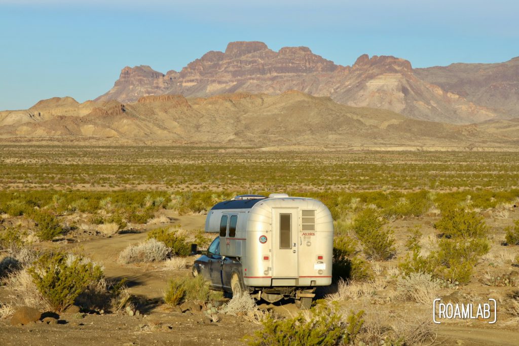 Golden 1970 Avion C11 trruck camper driving towards the Chisos Mountains in the Big Bend National Park in south west Texas.