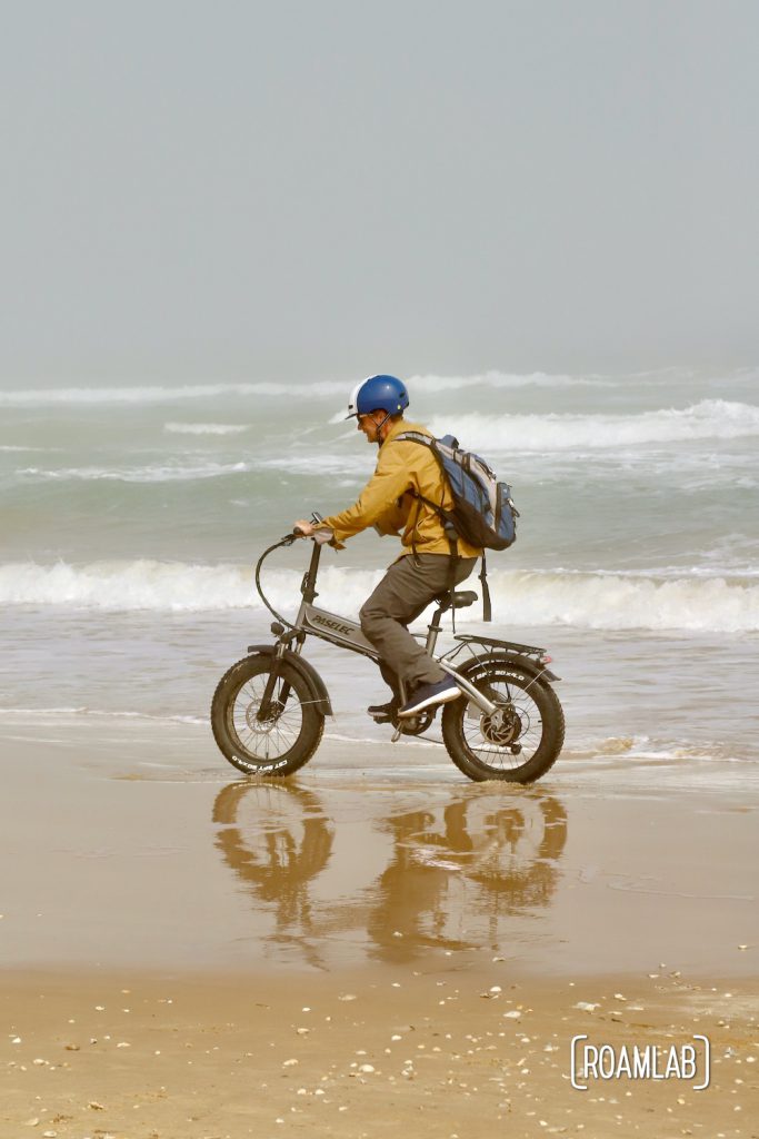 Man biking along the beach in South Padre Island, Texas