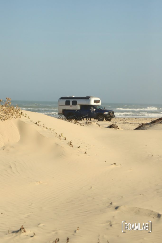 Vintage 1970 Avion C11 truck camper parked among the dunes in South Padre Island, Texas
