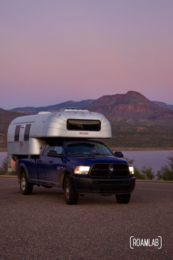 1970 Avion C11 truck camper parked at Cholla Campground with Roosevelt Lake in the background at sunset.