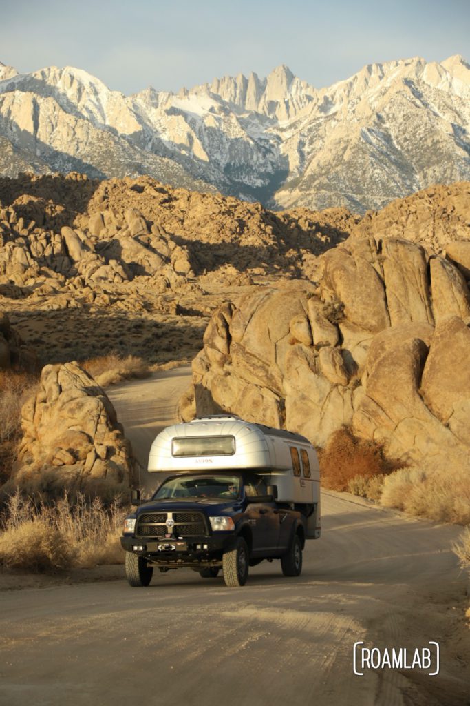 1970 Avion C11 truck campere driving up a winding stretch of Movie Road in the Alabama Hills with Mount Whitney in the background.