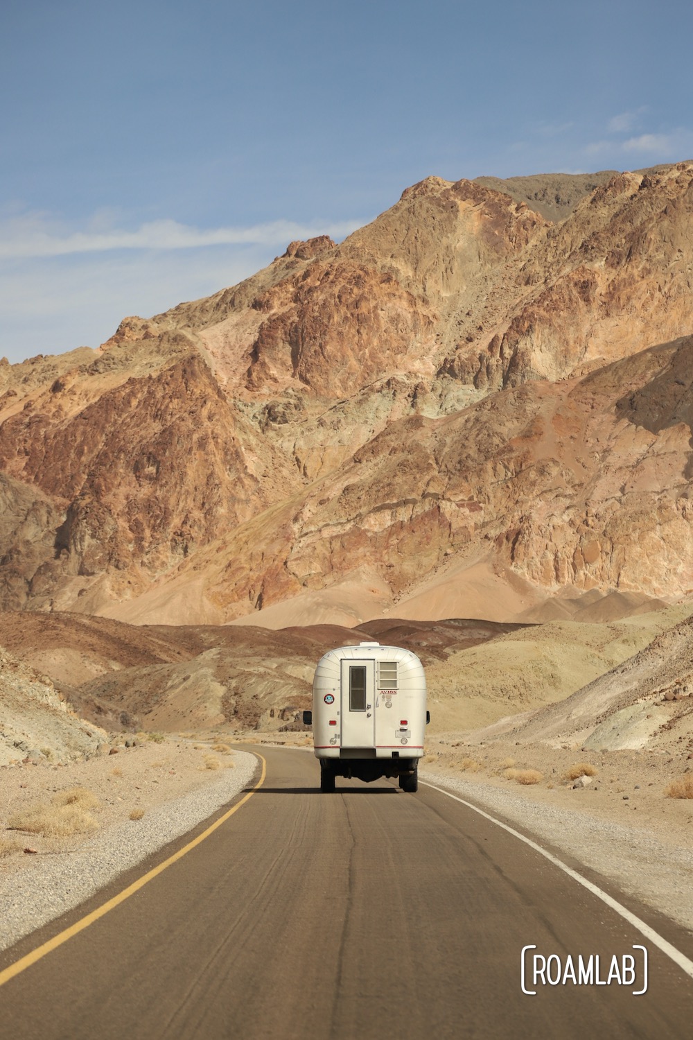 1970 Avion C11 truck camper driving down Artists Dive Scenic Loop in Death Valley National Park