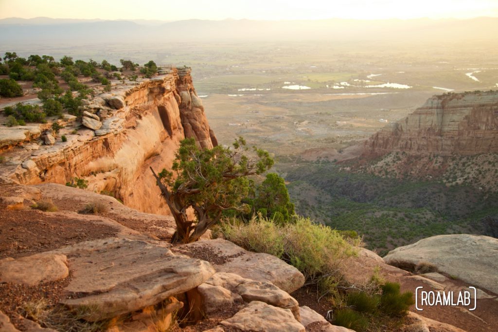 Vista of red rock cliffs in Colorado National Monument with Grand Junction below.