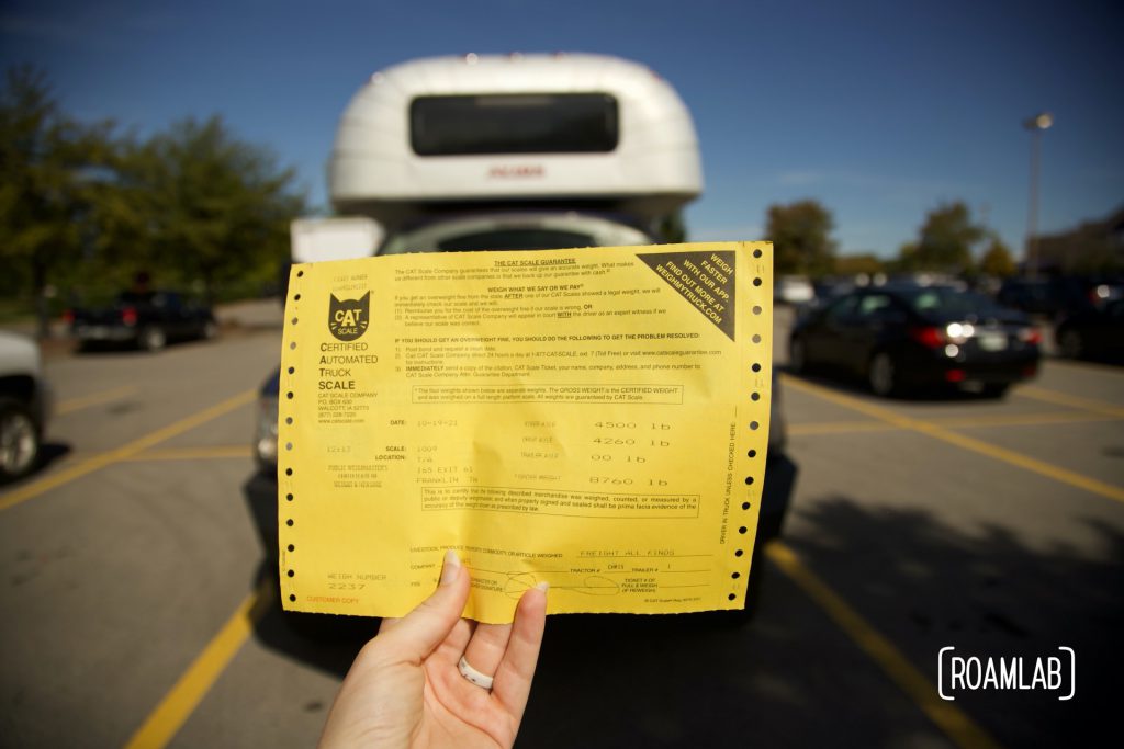 Hand holding up yellow paper with CAT Scale print out results.