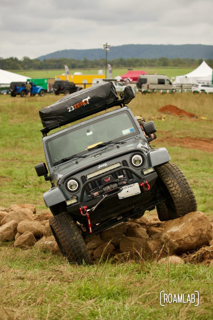 Dark grey Jeep crawling over boulders at Overland Expo East 2021 in Arrington, Virginia.