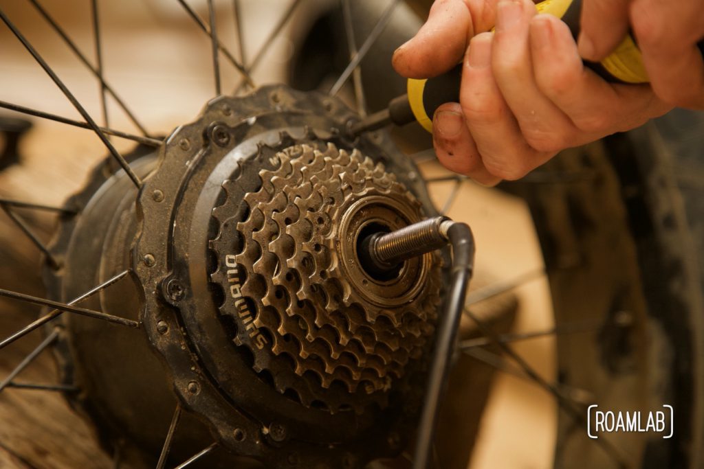 Hand securing sprocket to an ebike wheel hub using a torque wrench.