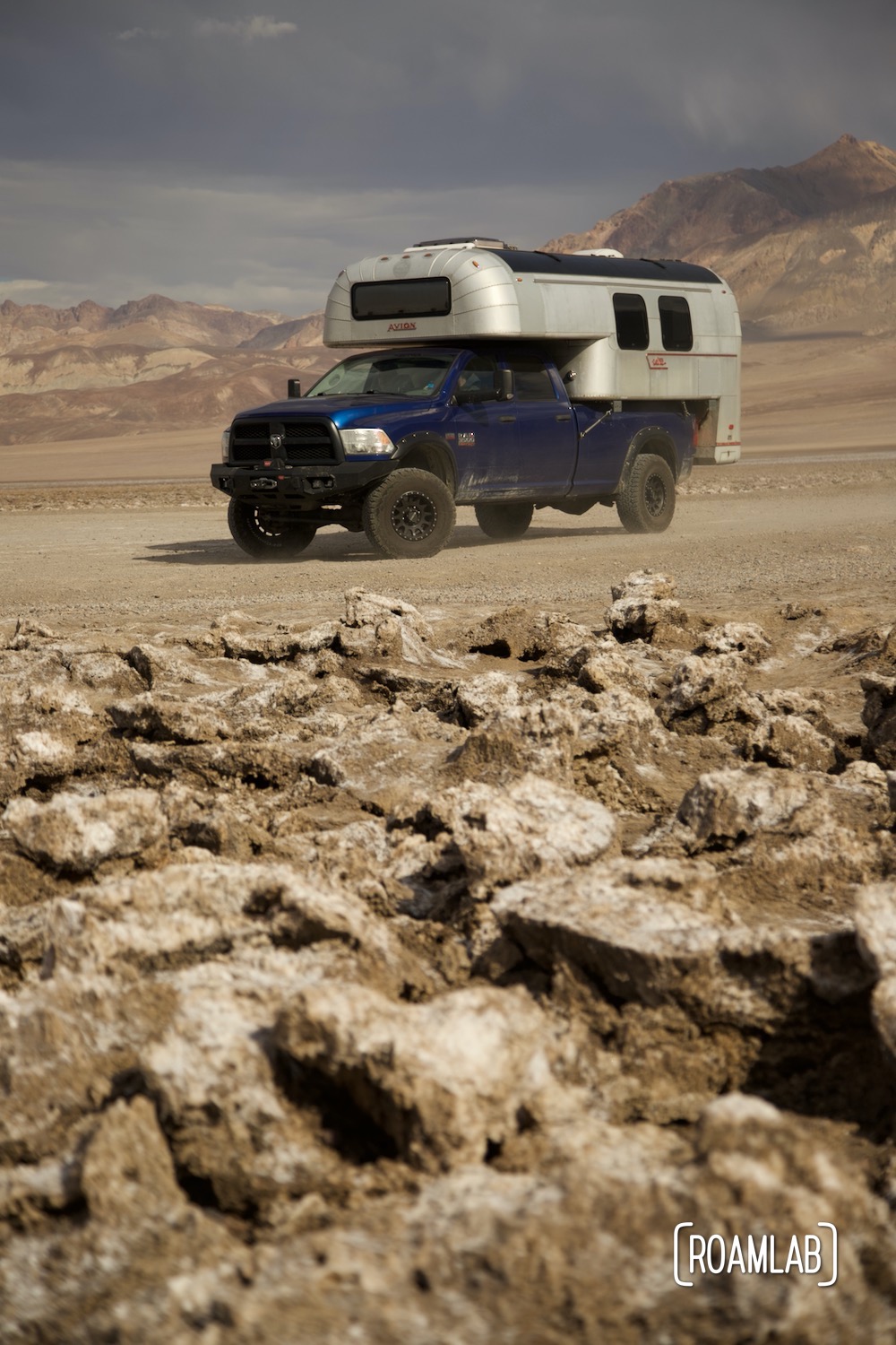 1970 Avion C11 truck camper parked in the Devil's Golf Course with the Amargosa Range in the background.