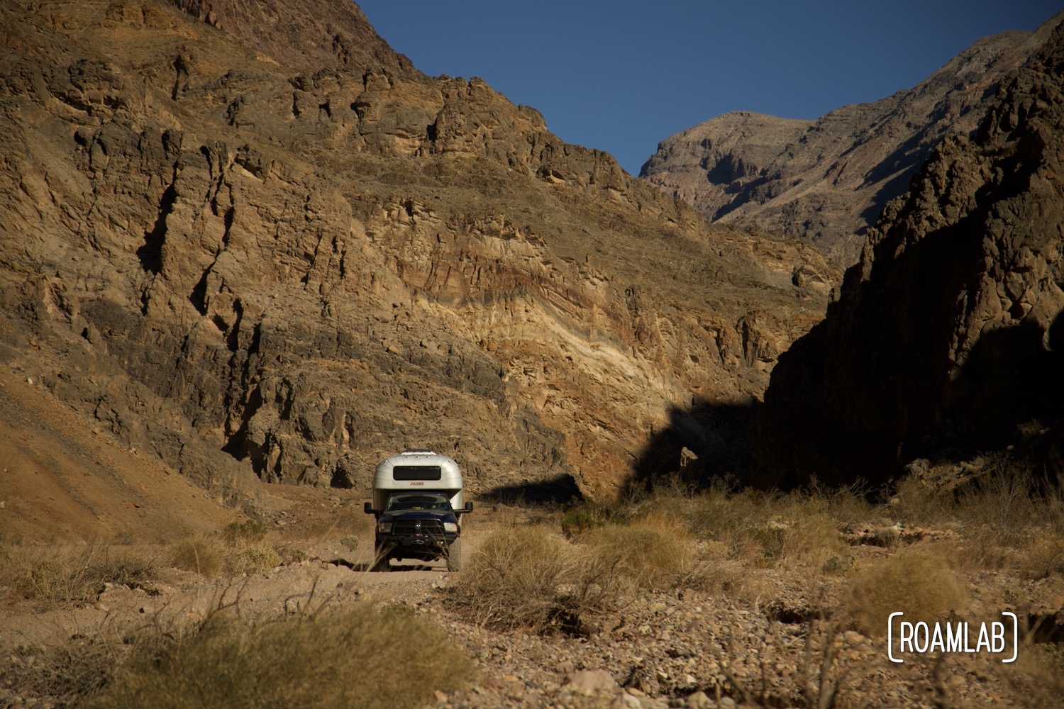 1970 Avion C11 truck camper swar following the dirt Titus Canyon Road in Death Valley National Park, California.
