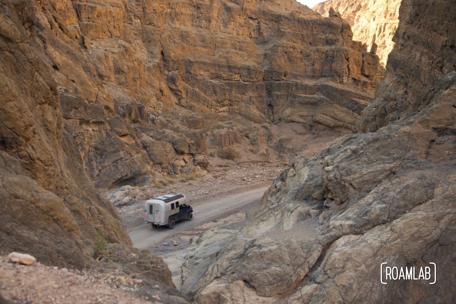 Overhead view of a 1970 Avion C11 truck camper following the dirt Titus Canyon Road in Death Valley National Park, California.