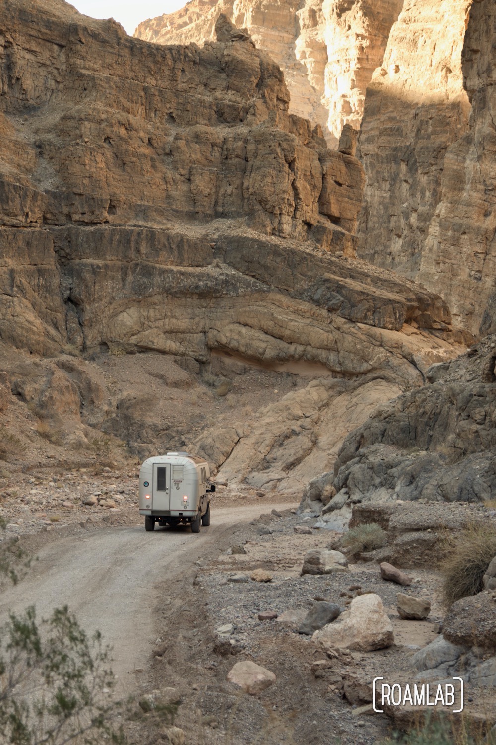 Slot canyon enveloping a 1970 Avion C11 truck camper following the dirt Titus Canyon Road in Death Valley National Park, California.