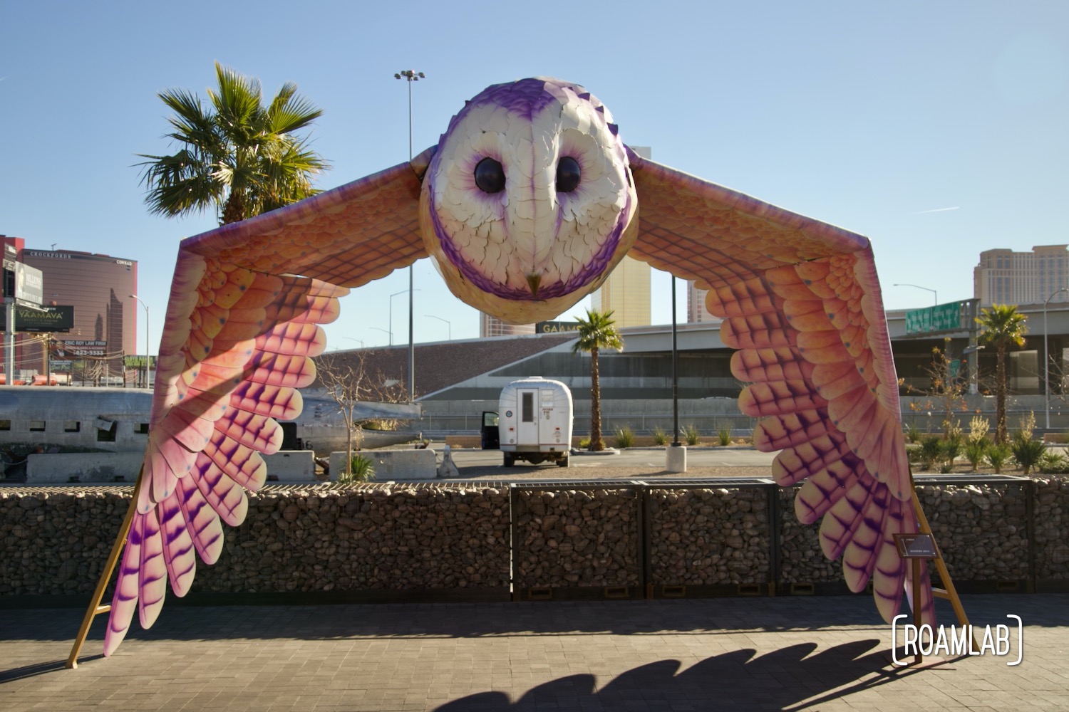 Owl statue outside of Area 15, hovering over our 1970 Avion C11 truck camper parked in the distance.