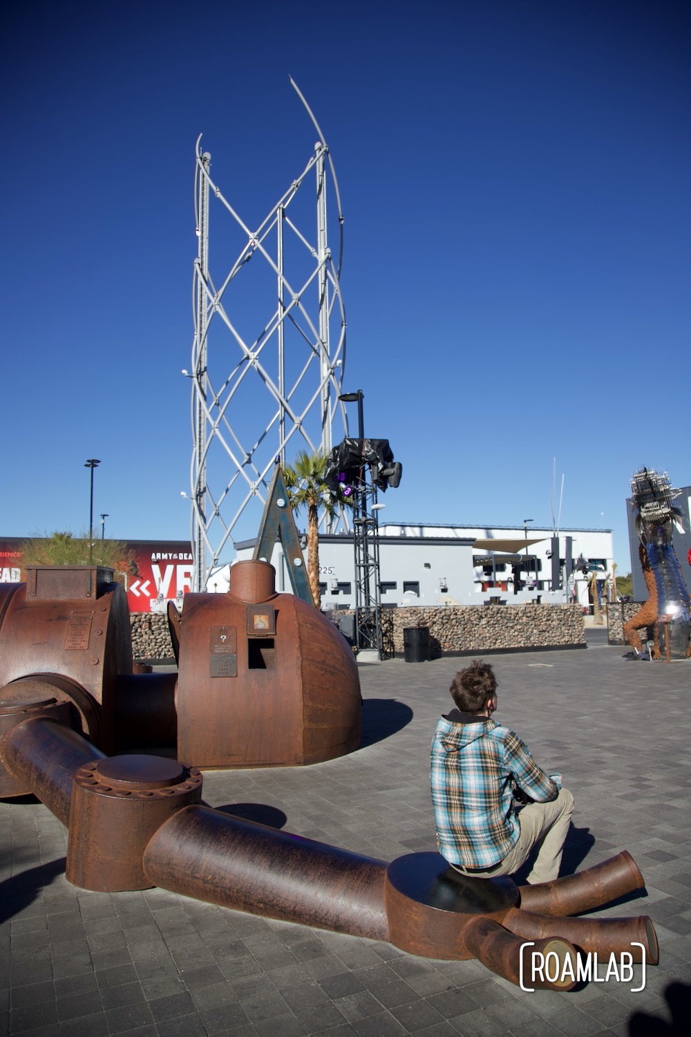 Man sitting in the hand of a rusting robot.