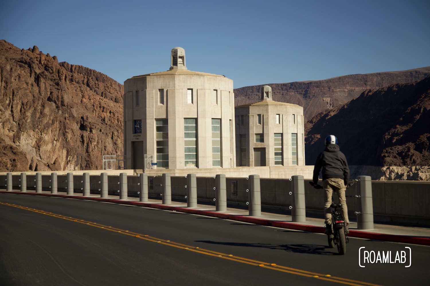 Man biking along the top of Hoover Dam.