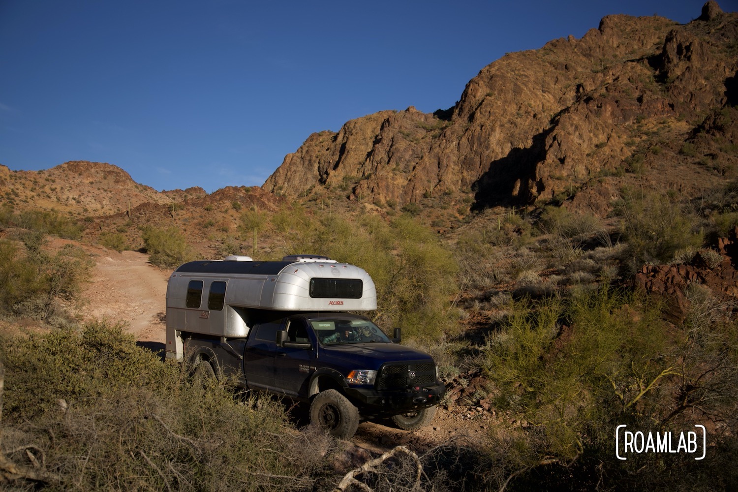 Avion C11 truck camper navigating a rocky dirt Castle Dome Mine Road in Kofa Wilderness Refuge.