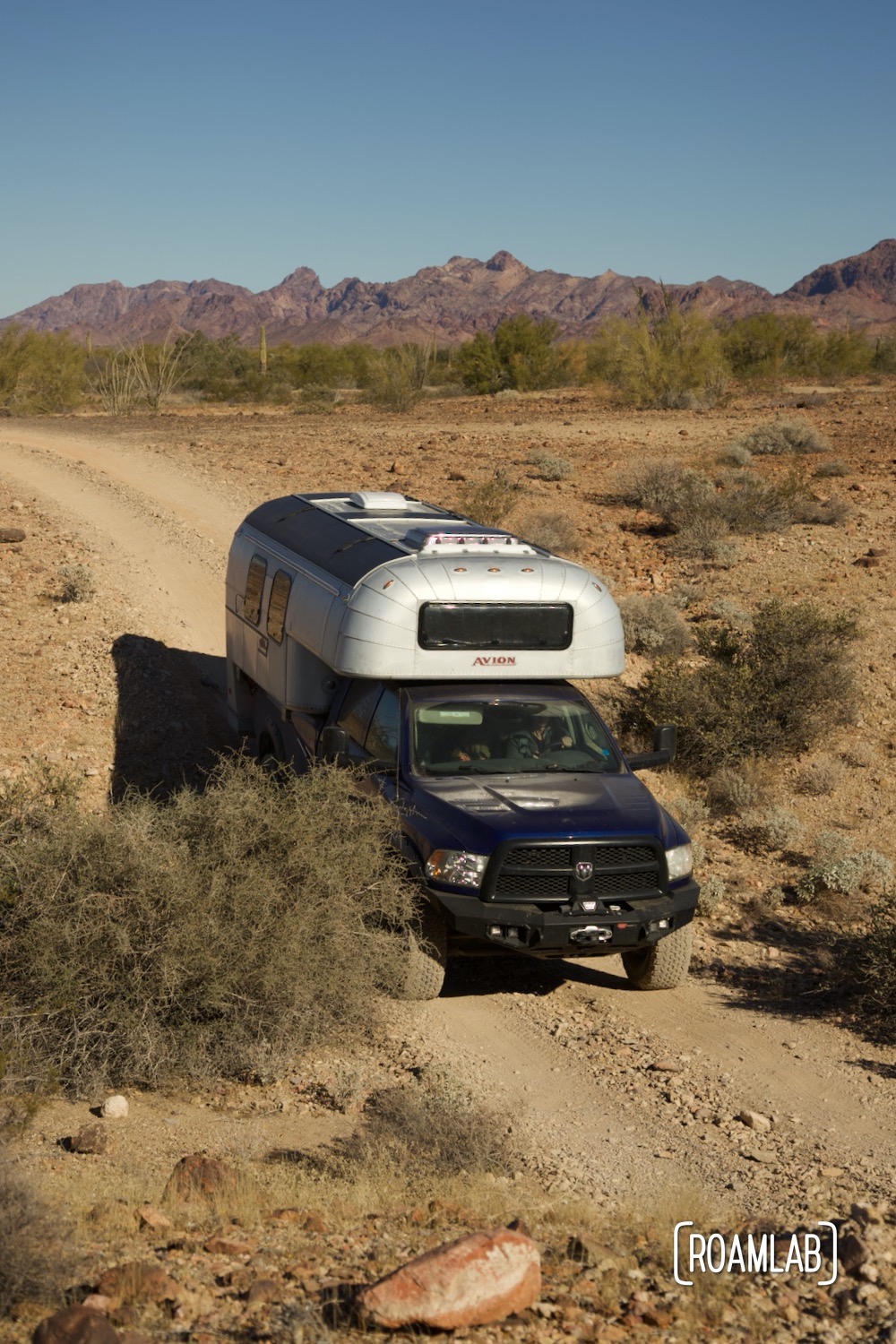 Avion C11 truck camper navigating a rocky dirt Castle Dome Mine Road in Kofa Wilderness Refuge.