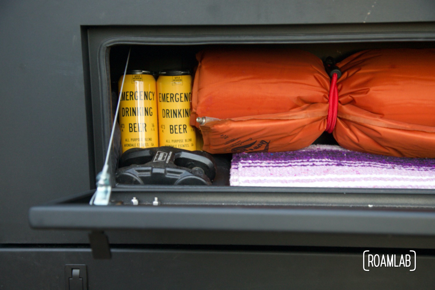 View in a Bowen Customs truck bed upper front storage box loaded with blankets, padding, and beer.
