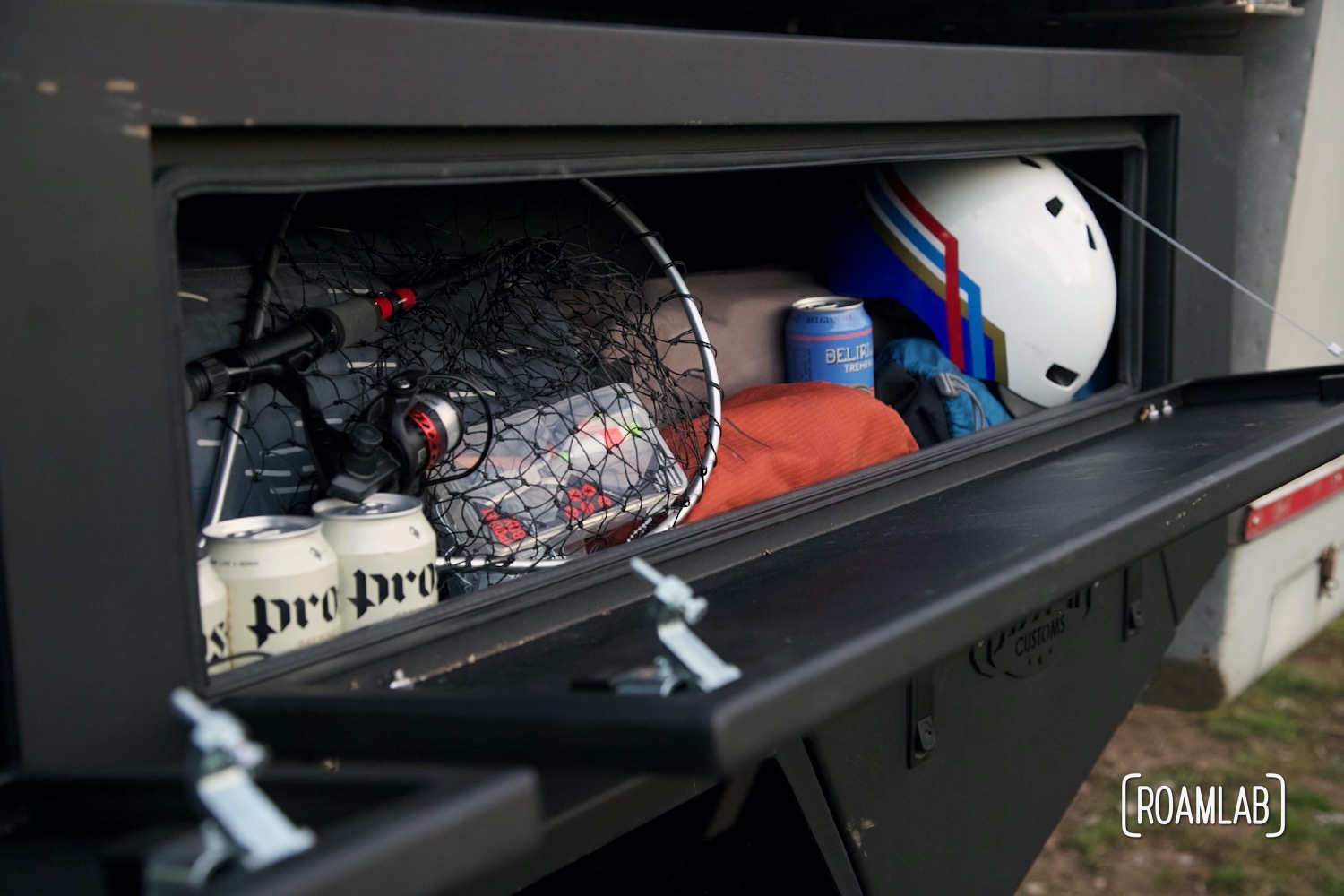 View in a Bowen Customs truck bed upper rear storage box loaded with fishing gear, helmets, and folding equipment.